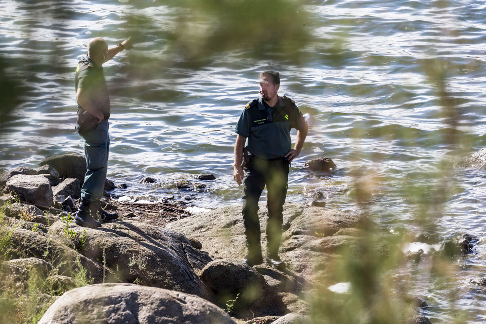 Dos agentes baten la orilla del pantano Guajaraz, ayer en Argés. 