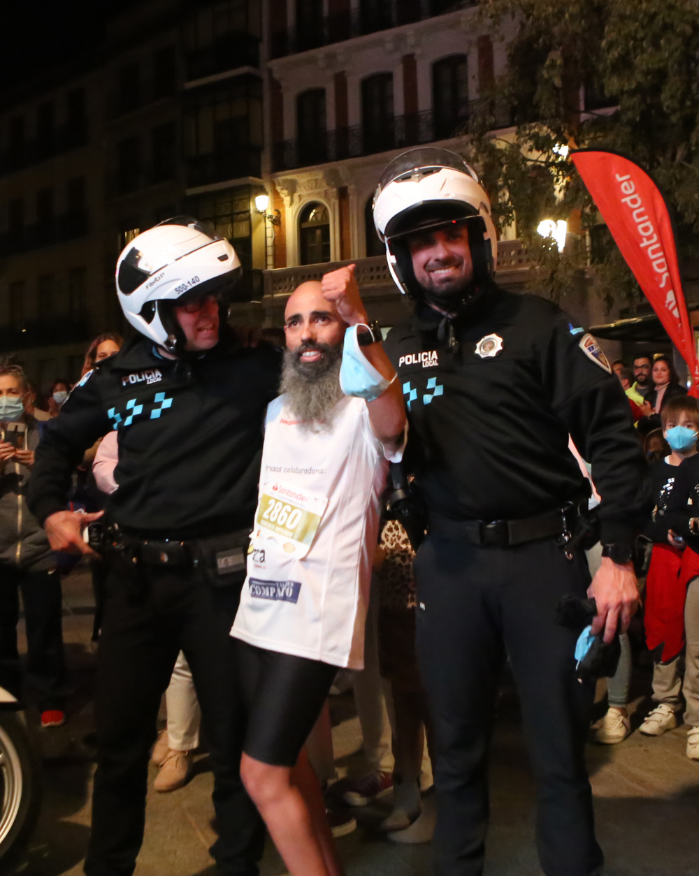 El atleta con discapacidad Paco Pérez posa con los policías locales que le escoltaron durante el recorrido tras cruzar la meta.