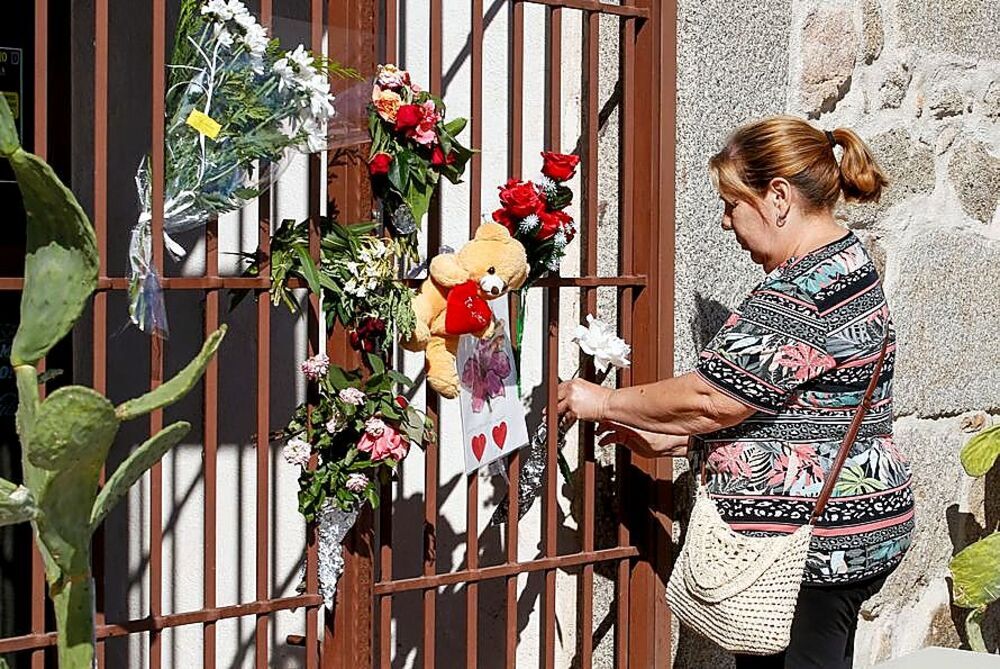 Rosa, una vecina de Pelahustán, coloca una flor en la cancela de ‘La boyería’. 