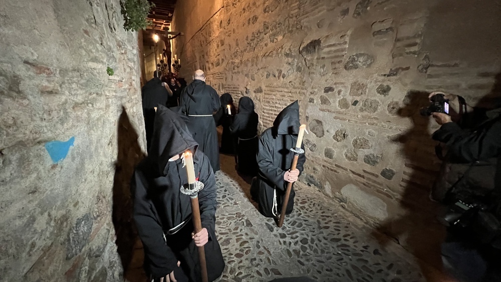 Algunos de los penitentes rezan arrodilados sobre el empedrado toledano cada una de la catorce estaciones del Viacrucis.