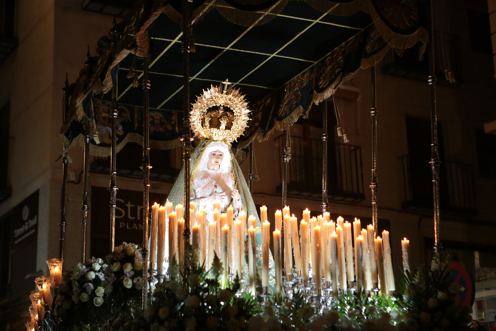 La Virgen del Amparo salió de la Catedral entre un bosque de rosas blancas y de velas.
