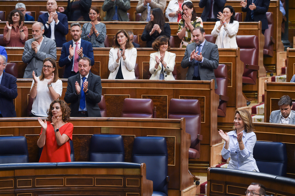 Varios diputados y ministros aplauden la aprobación de la Ley de la Vivienda durante una sesión plenaria en el Congreso de los Diputados.