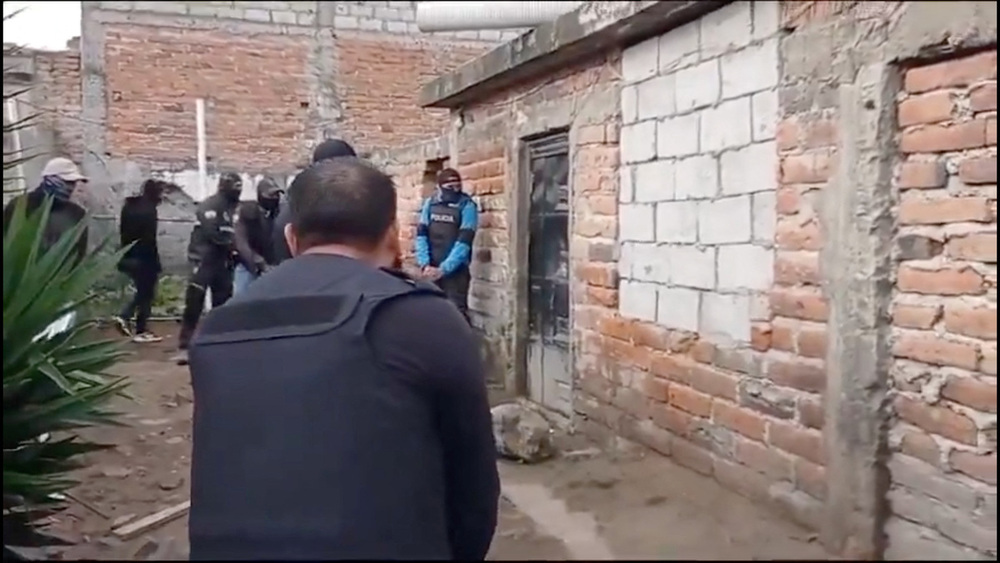Agentes policiales de Ecuador se posicionan fuera de una casa durante un operativo